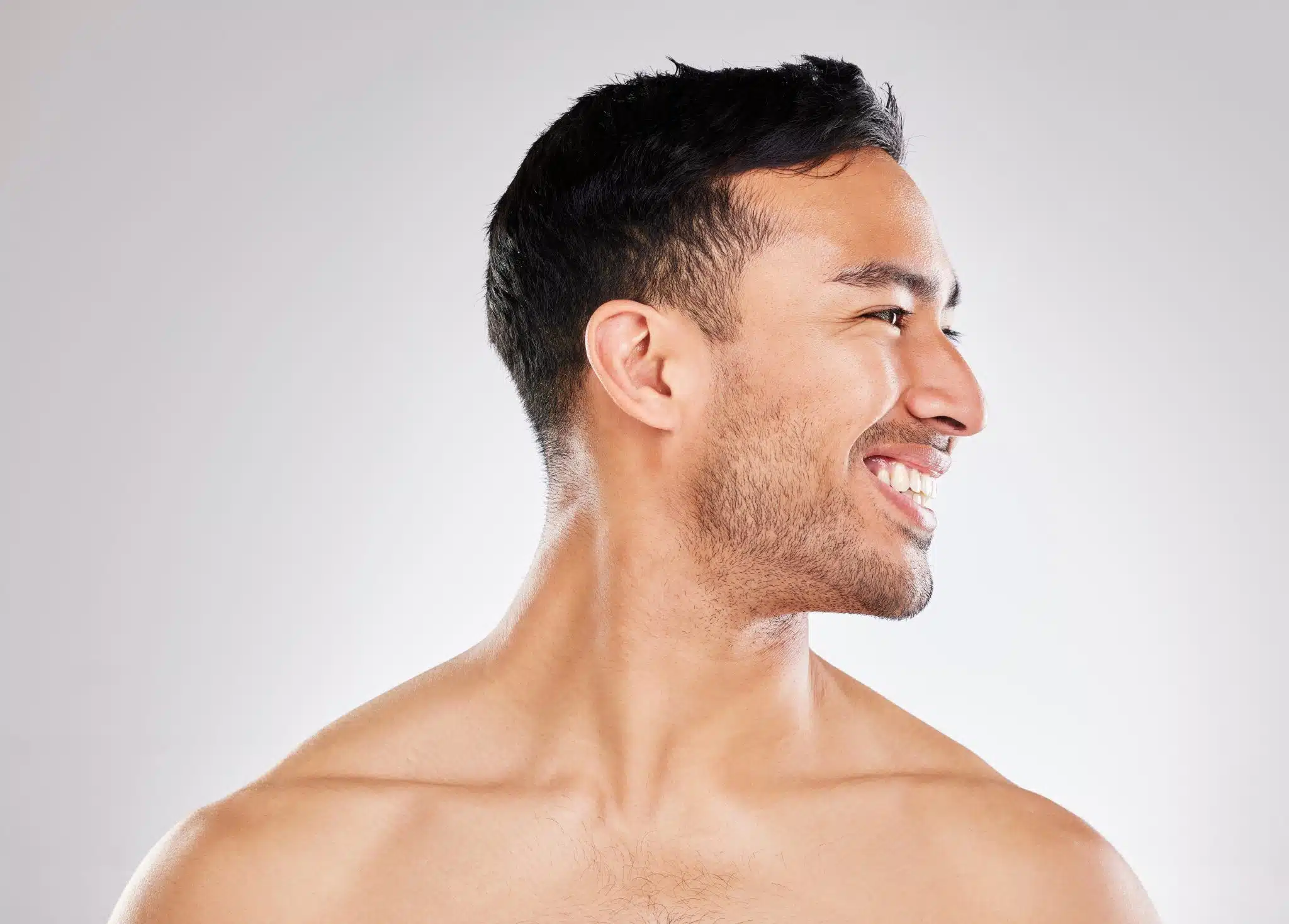 Hombre de pelo corto sonríe de perfil sobre fondo claro, imagen simbólica sobre Marcación mandibular en BONITAS Núremberg