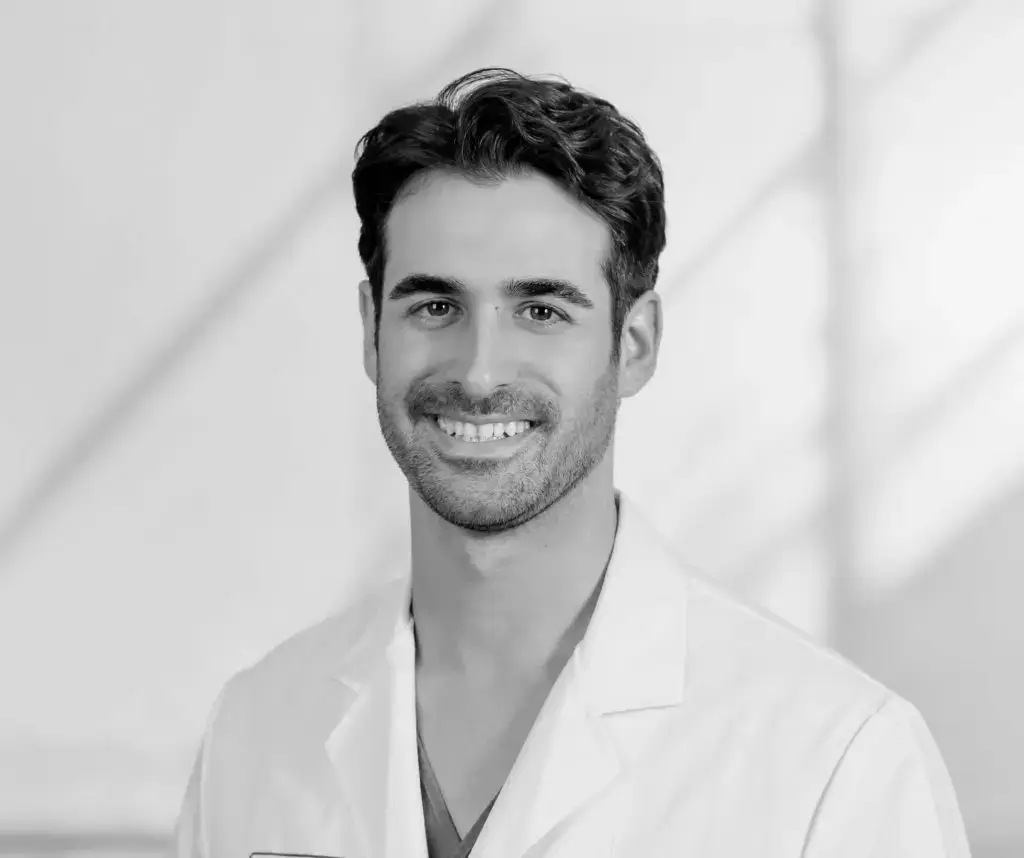 Lächelnder Mann mit dunklem Haar und Bart im weißen Kittel vor hellem Hintergrund: Alejandro Marti, Facharzt für Plastische und Ästhetische Chirurgie, BONITAS Nürnberg