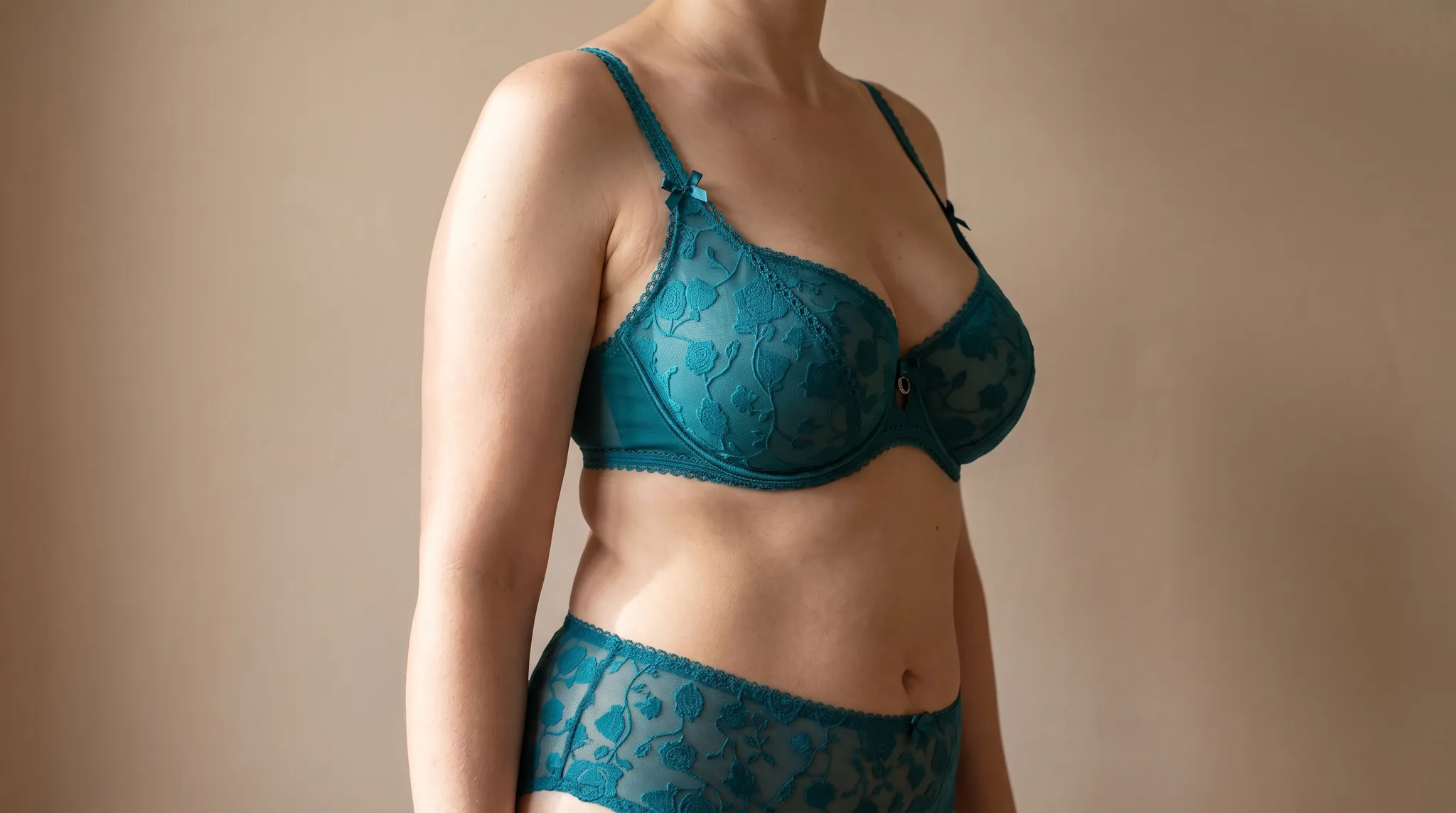Torso de una mujer con pecho de forma natural, con lencería de encaje color petróleo, imagen simbólica sobre los pezones invertidos en BONITAS Núremberg