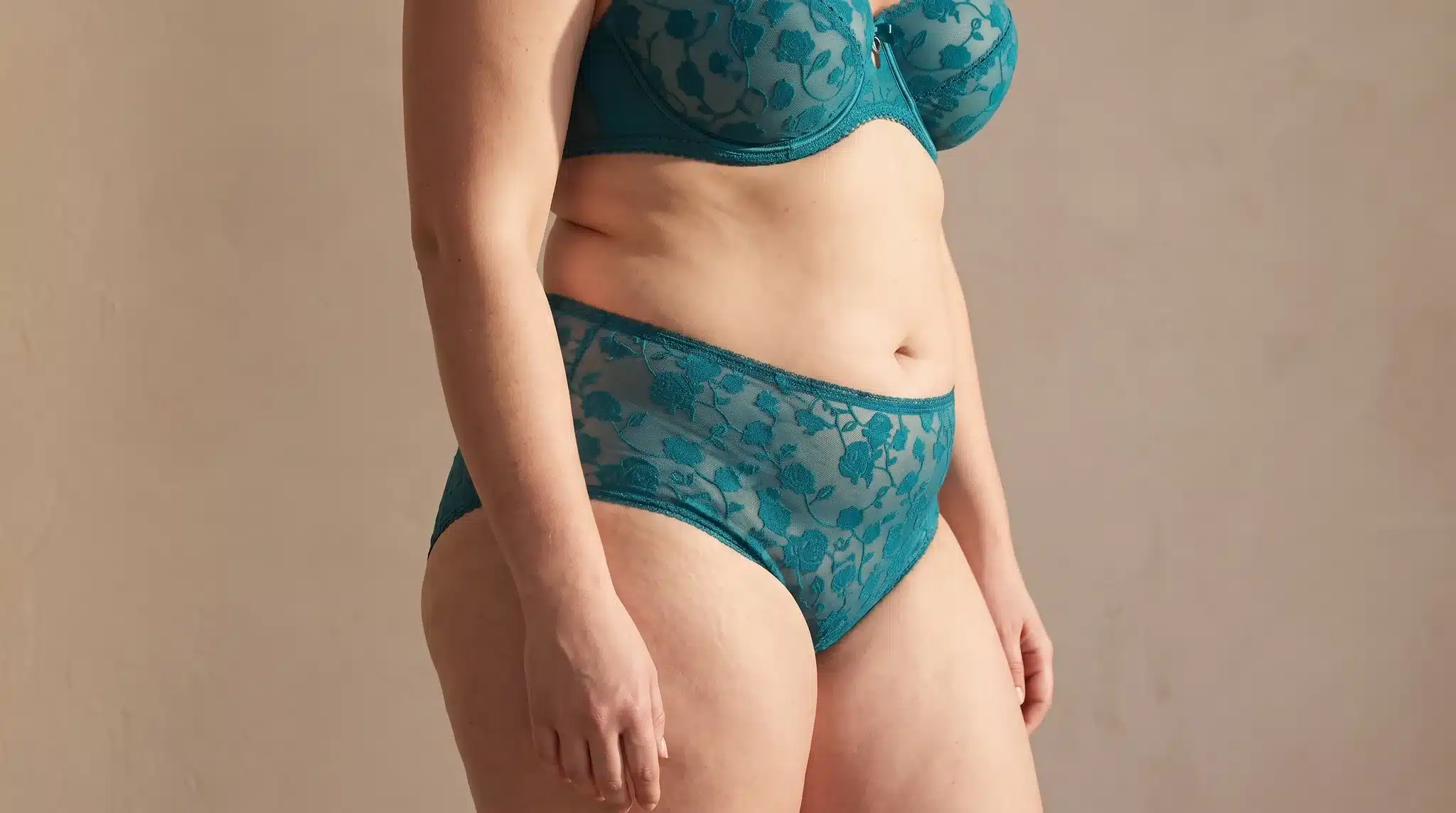 Bauch und Hüften einer Frau mit weichem, gerundetem Unterbauch und kräftigen Hüften, in petrolfarbener Spitzenwäsche, Symbolbild zum Thema Lipödem am Bauch bei BONITAS in Nürnberg